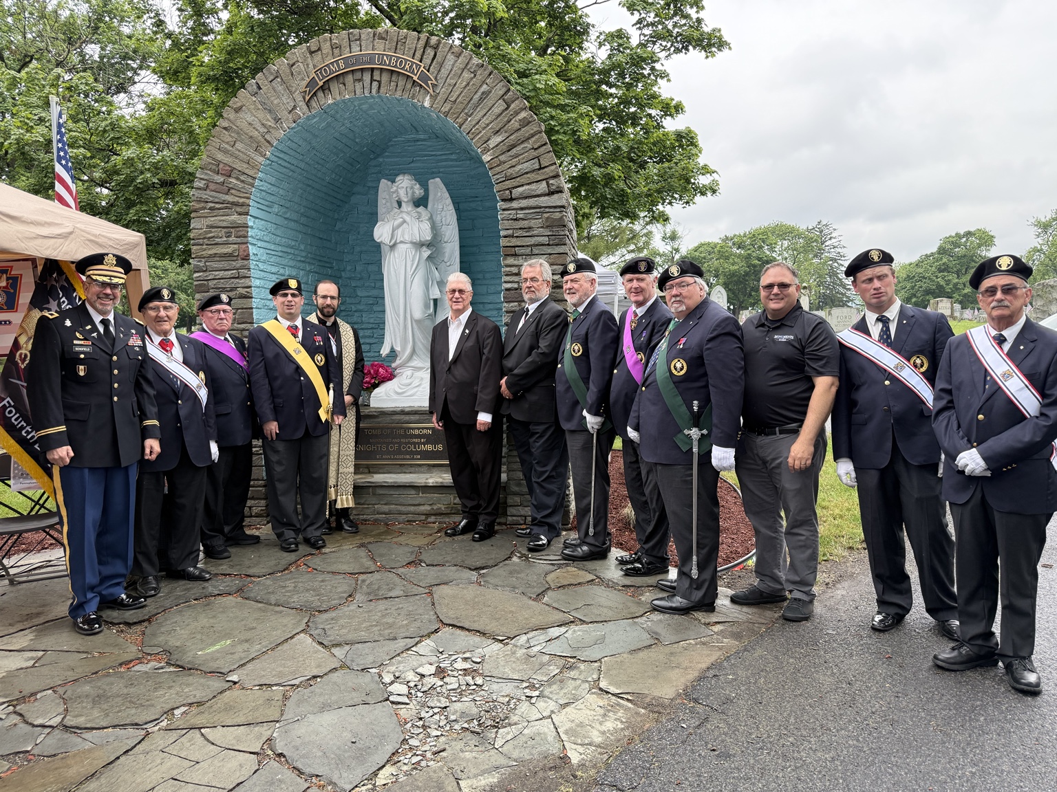 Assembly members and clergy at the Tomb of the Unborn dedication on Flag Day 2025.